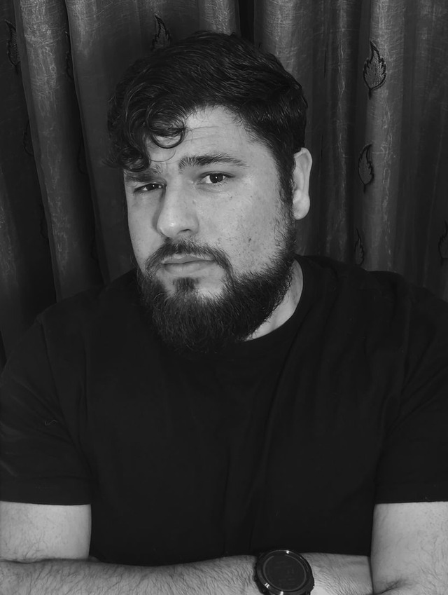 Retrato en blanco y negro de David P. Quevedo, con barba y los brazos cruzados